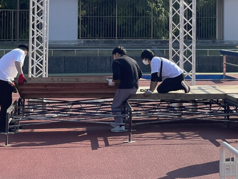 APステージ（当商品）と一般的なステージの比較画像。APステージは頑丈で傾斜にも対応、一般的なステージは横揺れに注意が必要。18トン耐荷重、ジャッキベース調整などの特徴を視覚化。